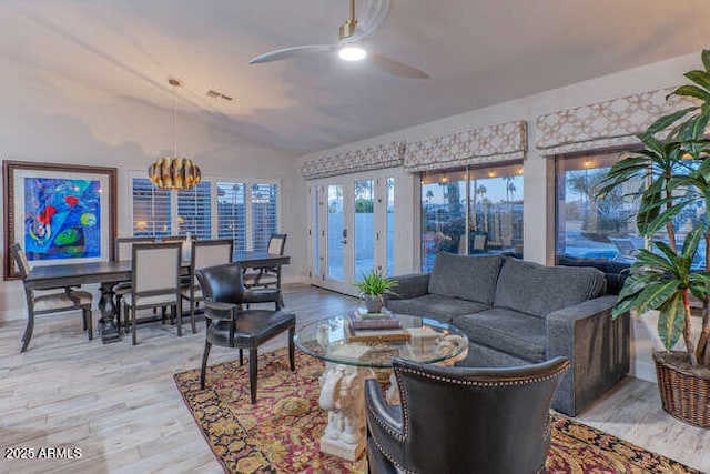 living room featuring ceiling fan, lofted ceiling, and wood-type flooring