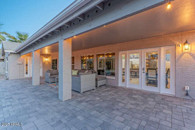 patio terrace at dusk with french doors and an outdoor hangout area