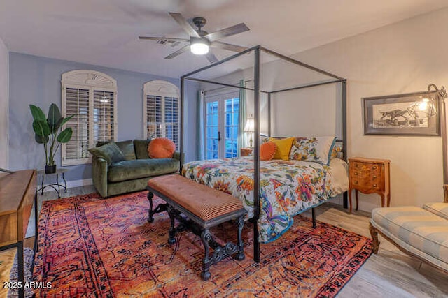 bedroom with wood-type flooring, ceiling fan, and french doors