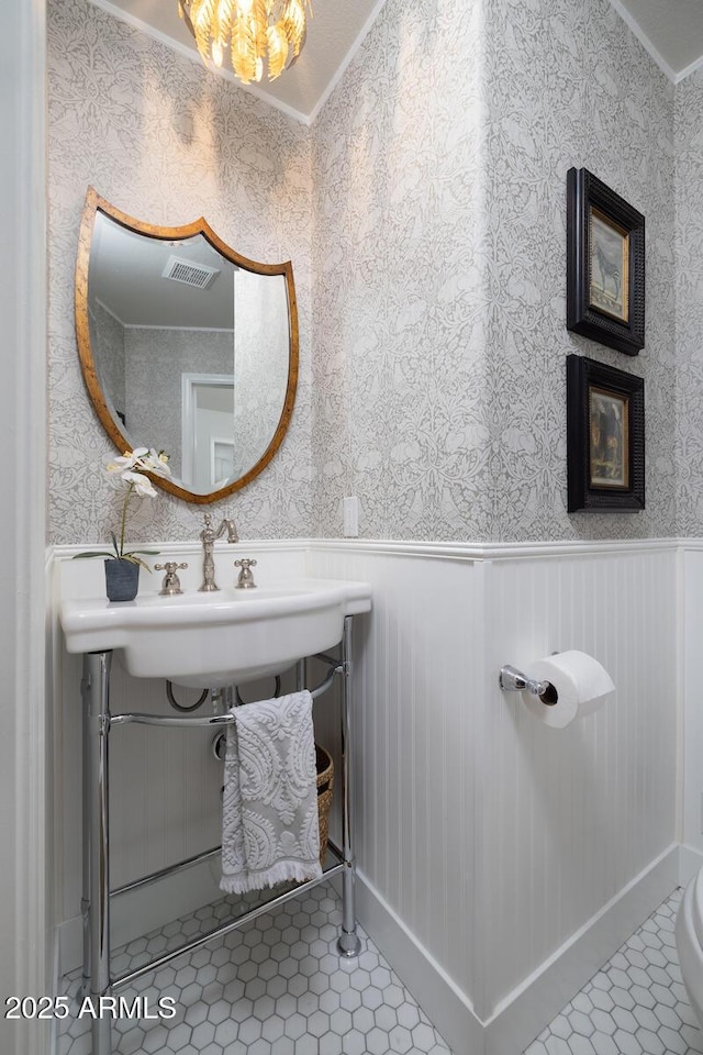 bathroom featuring ornamental molding, sink, and tile patterned flooring