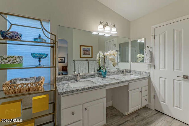 bathroom featuring vanity, vaulted ceiling, and hardwood / wood-style floors