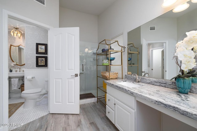 bathroom featuring an enclosed shower, sink, wood-type flooring, and toilet