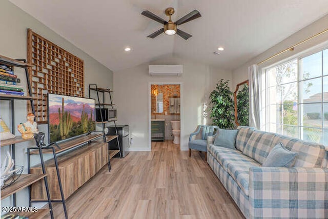 living room with vaulted ceiling, a wall unit AC, ceiling fan, and light wood-type flooring