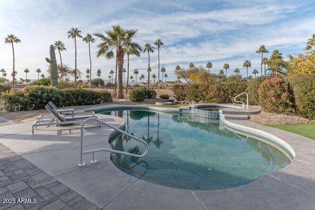 view of swimming pool featuring an in ground hot tub and a patio area