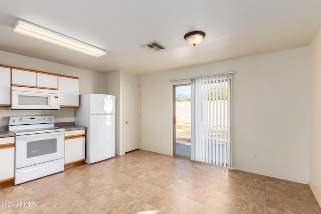 kitchen with white cabinets and white appliances