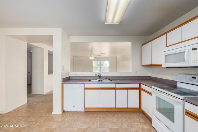 kitchen with white appliances, white cabinets, sink, ceiling fan, and light colored carpet