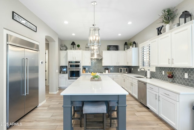 kitchen featuring a sink, decorative backsplash, white cabinetry, and stainless steel appliances