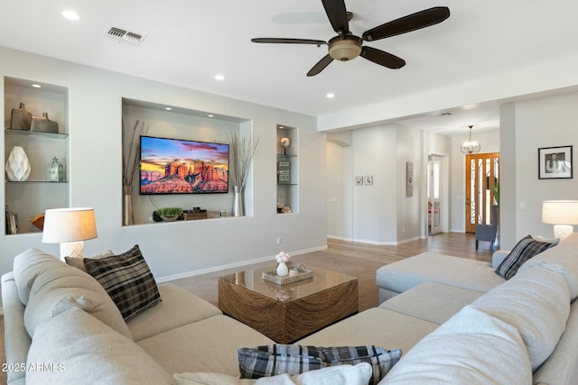living room with a notable chandelier, visible vents, recessed lighting, and baseboards