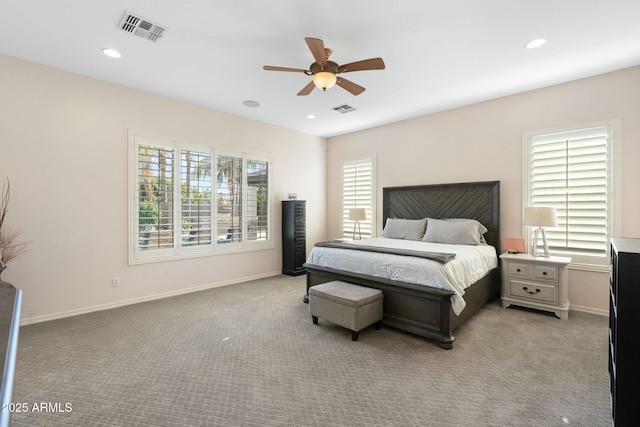 bedroom featuring visible vents, multiple windows, and light carpet