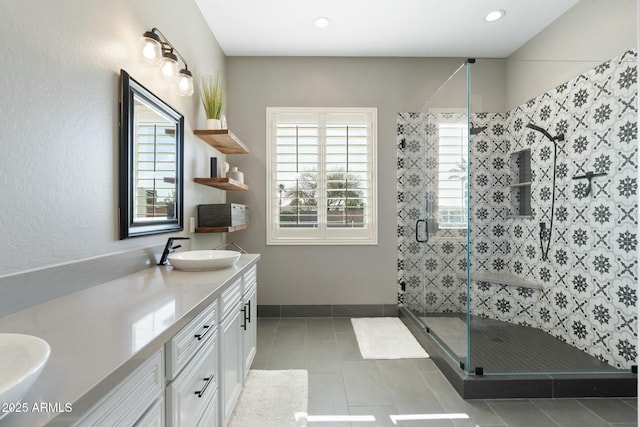 bathroom with baseboards, a stall shower, vanity, and tile patterned flooring