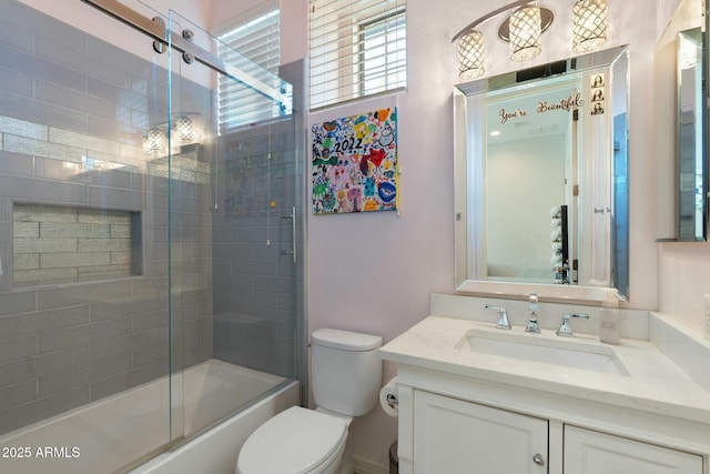 bathroom with toilet, vanity, and shower / bath combination with glass door