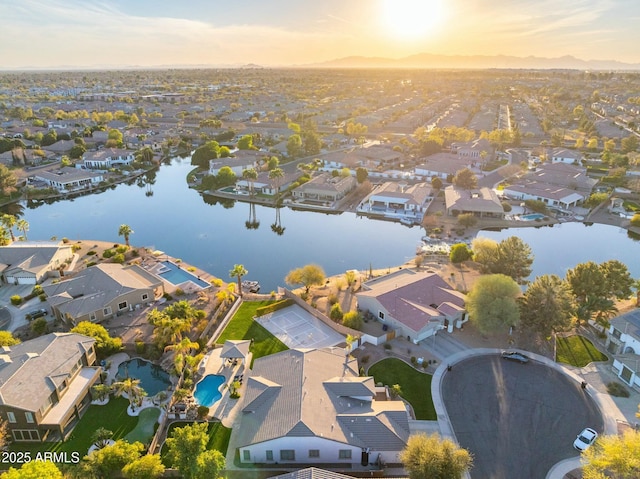 aerial view at dusk with a residential view and a water view