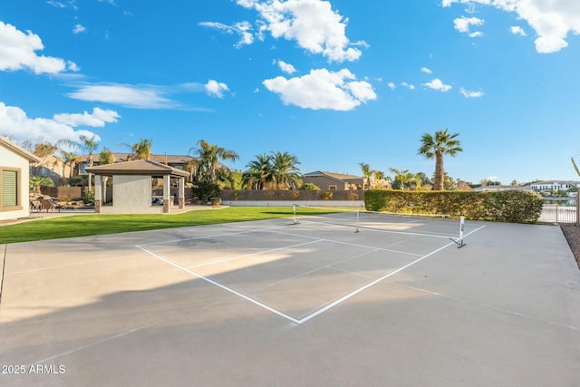 view of sport court with a gazebo, fence, and a lawn