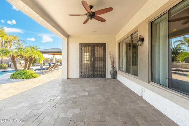 view of patio / terrace with an outdoor pool and a ceiling fan