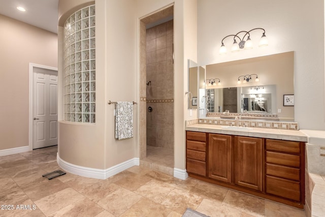 bathroom with tiled shower and vanity