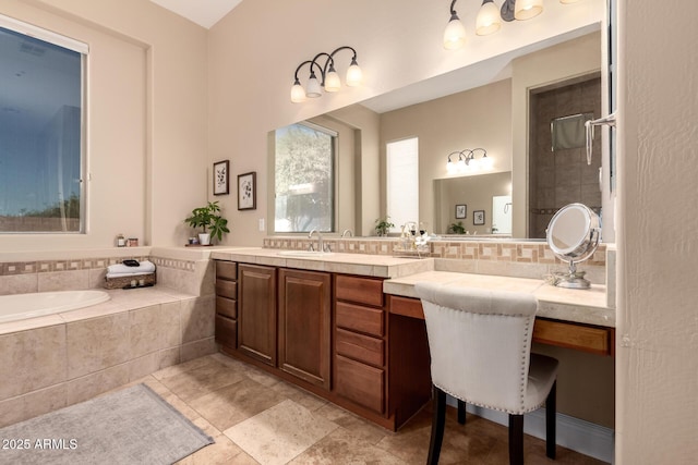 bathroom with vanity, tiled tub, and decorative backsplash