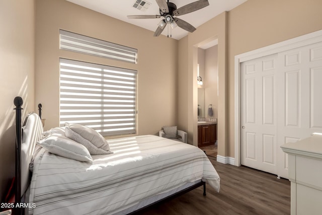 bedroom with ensuite bathroom, dark hardwood / wood-style floors, ceiling fan, and a closet