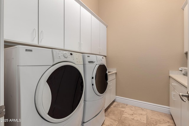 washroom with cabinets and washing machine and clothes dryer