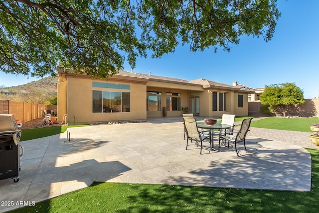 back of property with a yard and a patio area