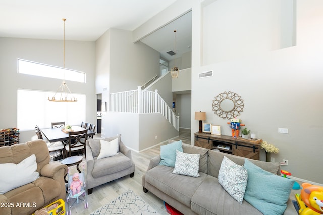 2224 W Olive Way, Chandler, AZ 85248 - living room with high vaulted ceiling, stairway, wood finished floors, baseboards, and a chandelier