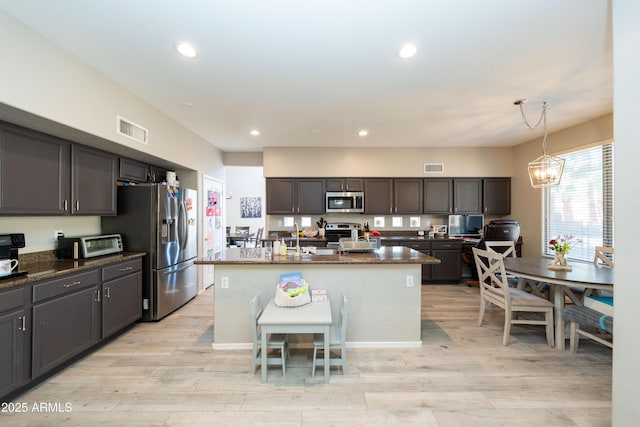 2224 W Olive Way, Chandler, AZ 85248 - kitchen with stainless steel appliances, recessed lighting, light wood-style flooring, a kitchen island with sink, and pendant lighting