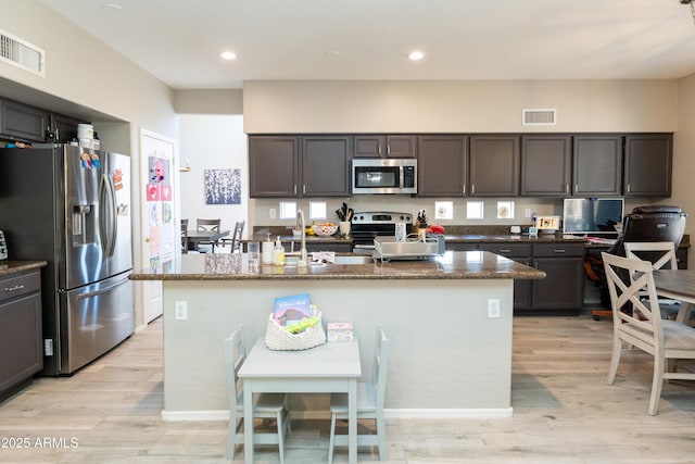 2224 W Olive Way, Chandler, AZ 85248 - kitchen featuring appliances with stainless steel finishes, light wood finished floors, a sink, dark stone counters, and recessed lighting
