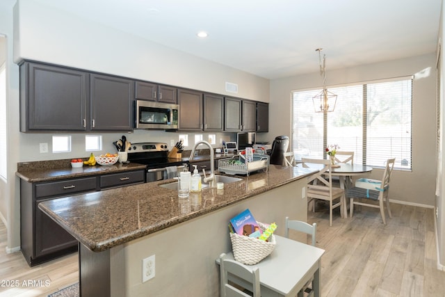 2224 W Olive Way, Chandler, AZ 85248 - kitchen featuring appliances with stainless steel finishes, a sink, baseboards, light wood-type flooring, and dark stone countertops