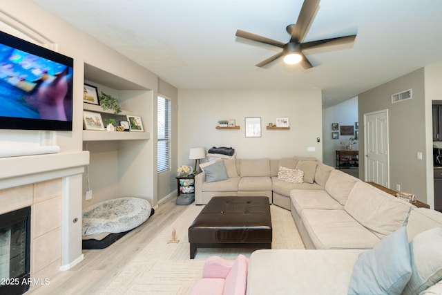 2224 W Olive Way, Chandler, AZ 85248 - living room with wood finished floors, a ceiling fan, a tiled fireplace, and baseboards
