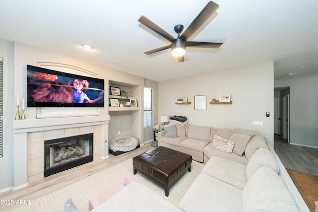 2224 W Olive Way, Chandler, AZ 85248 - living room with wood finished floors, ceiling fan, a tiled fireplace, and baseboards