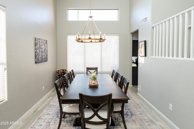 2224 W Olive Way, Chandler, AZ 85248 - dining space featuring light wood-type flooring, a towering ceiling, a chandelier, and baseboards