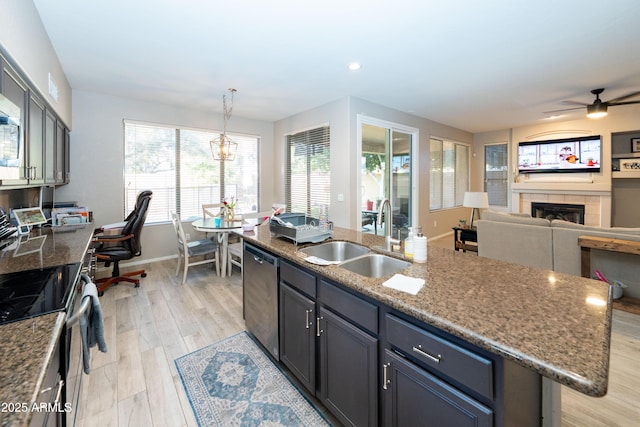 2224 W Olive Way, Chandler, AZ 85248 - kitchen featuring a sink, appliances with stainless steel finishes, a kitchen island with sink, a tile fireplace, and light wood finished floors