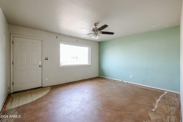 foyer entrance with ceiling fan and concrete floors