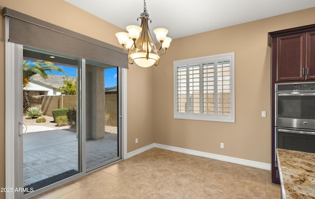 unfurnished dining area with a notable chandelier and baseboards