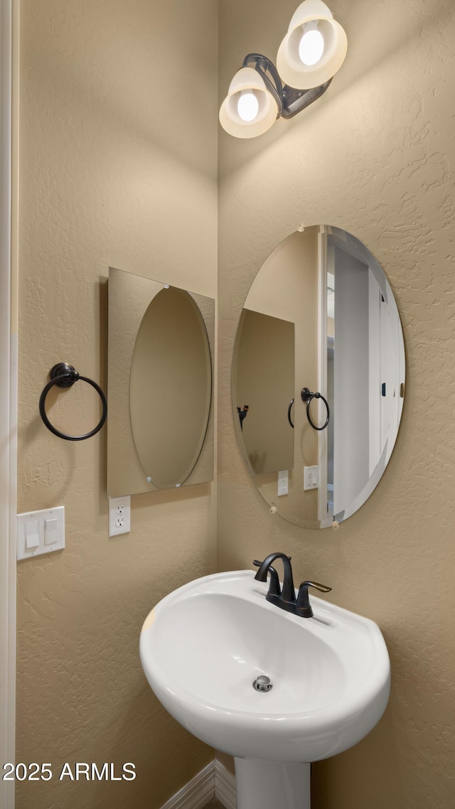 bathroom featuring a textured wall and a sink