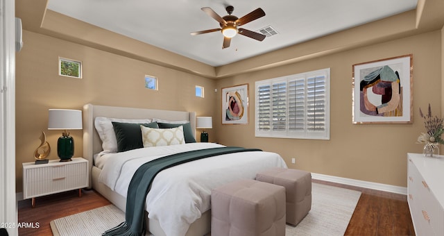 bedroom with visible vents, baseboards, and wood finished floors