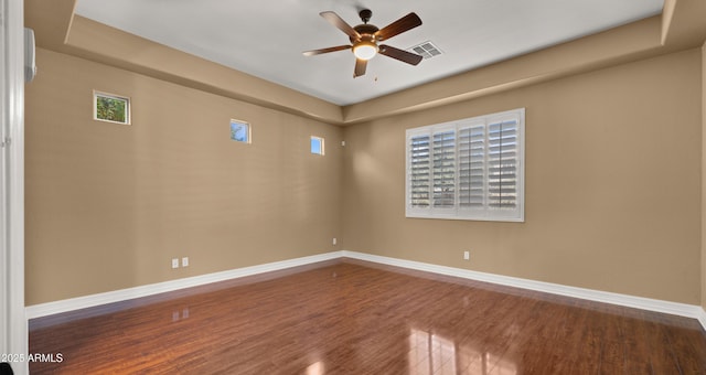 unfurnished room with visible vents, baseboards, ceiling fan, and wood finished floors