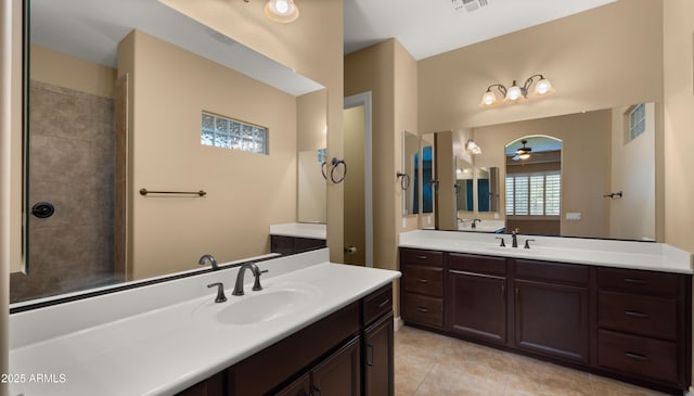 full bathroom featuring visible vents, two vanities, ceiling fan, and a sink