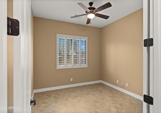 spare room featuring baseboards and a ceiling fan