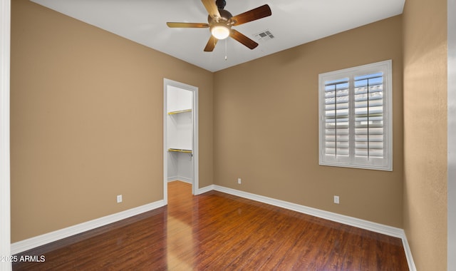 unfurnished room featuring visible vents, wood finished floors, baseboards, and ceiling fan