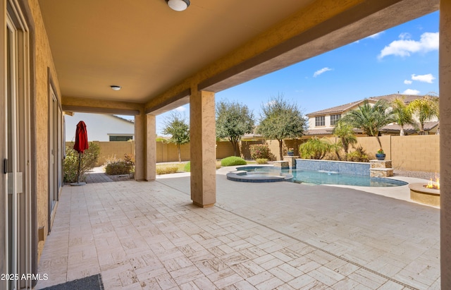 view of patio with a fenced backyard and a pool with connected hot tub