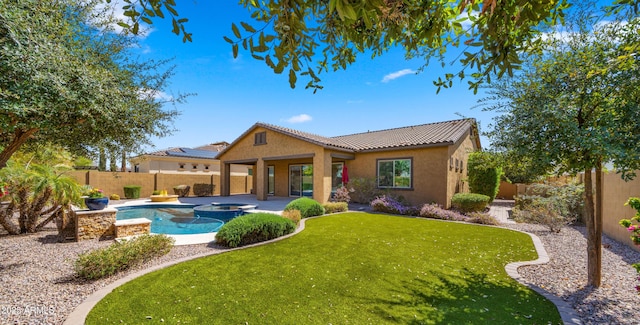 back of property with a tile roof, stucco siding, a yard, a fenced backyard, and a patio