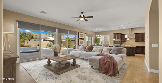 living area with visible vents, baseboards, light tile patterned flooring, recessed lighting, and ceiling fan with notable chandelier