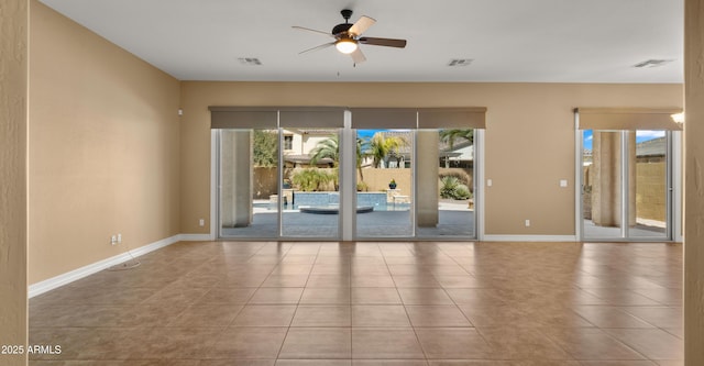 tiled empty room featuring visible vents, baseboards, and a ceiling fan