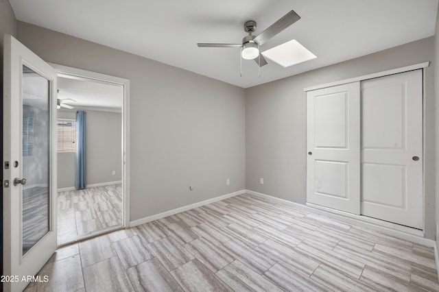 405 W Monte Way, Phoenix, AZ 85041 - unfurnished bedroom featuring wood finished floors, a skylight, baseboards, a closet, and ceiling fan