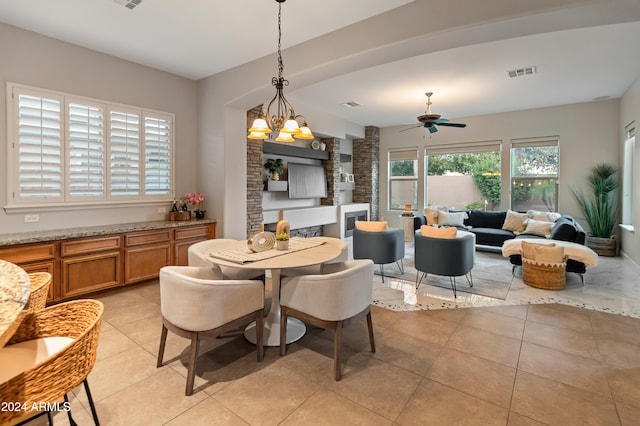 tiled dining room featuring ceiling fan with notable chandelier