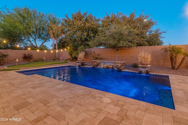 pool at dusk with pool water feature