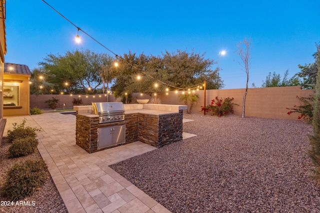 patio terrace at dusk with grilling area and exterior kitchen