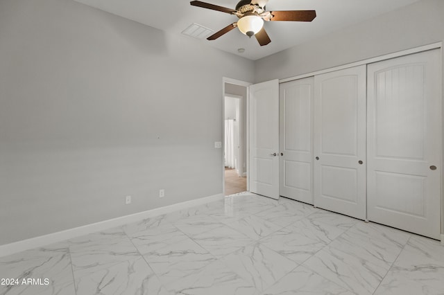 unfurnished bedroom with ceiling fan and a closet