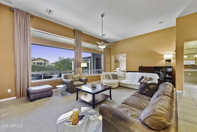 living room featuring visible vents, baseboards, and a ceiling fan