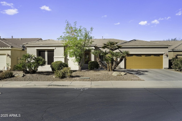 view of front of house featuring a garage, a tiled roof, concrete driveway, and stucco siding